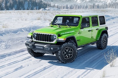 Mojito green Jeep Wrangler Rubicon with a white hardtop on a snowy road